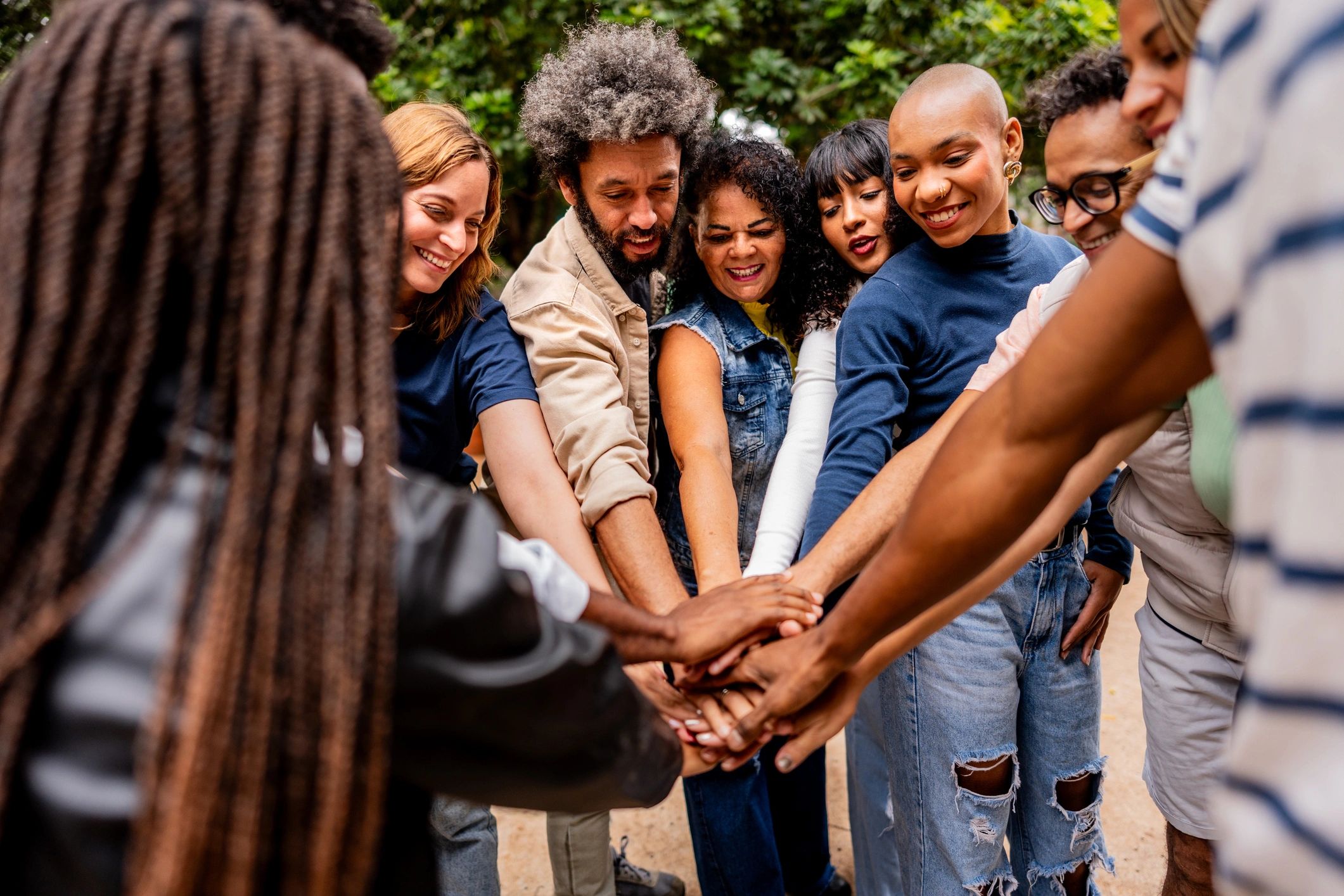 Group of people stacking hands outdoors